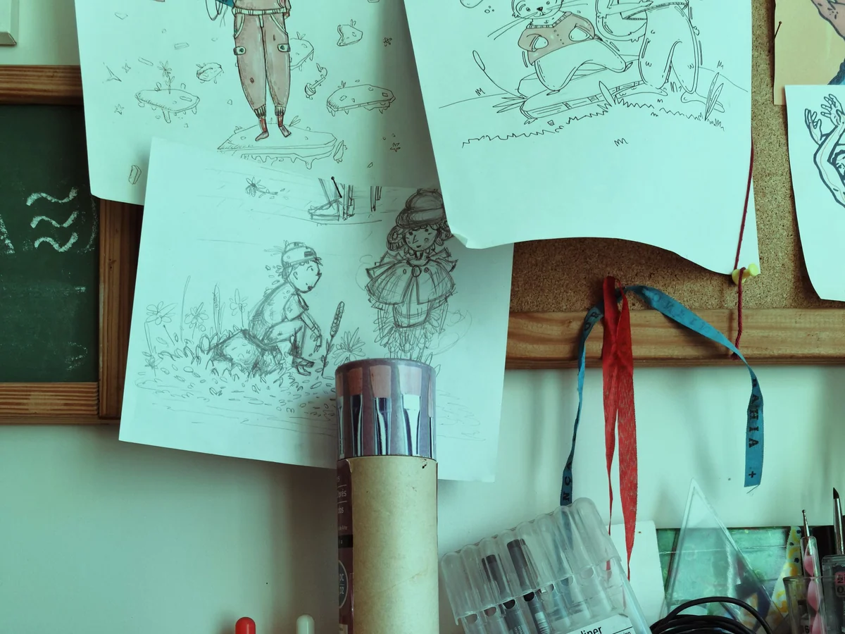 Woman planning a creative project in an open notebook at a studio desk