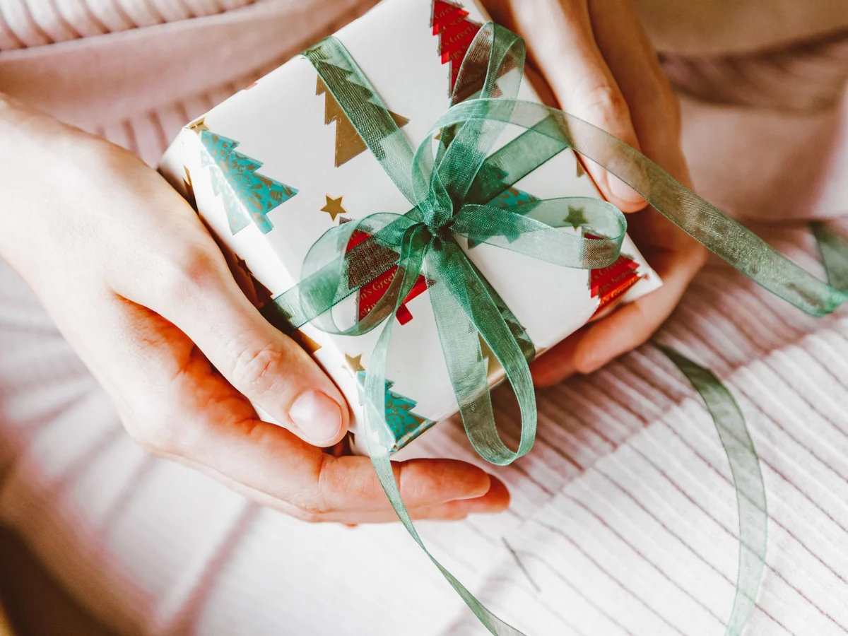 Friends arranging wrapped gifts for an inclusive holiday exchange