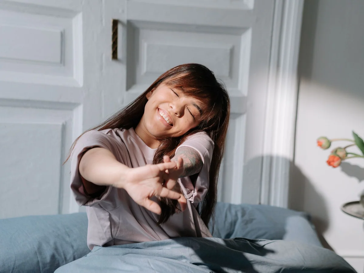 Woman preparing a compact guest sleeping area in a studio apartment