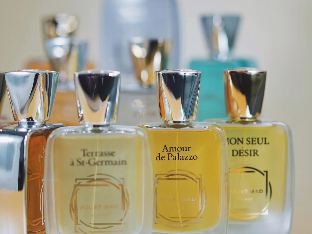 Woman comparing perfume sample vials at a quiet dressing table
