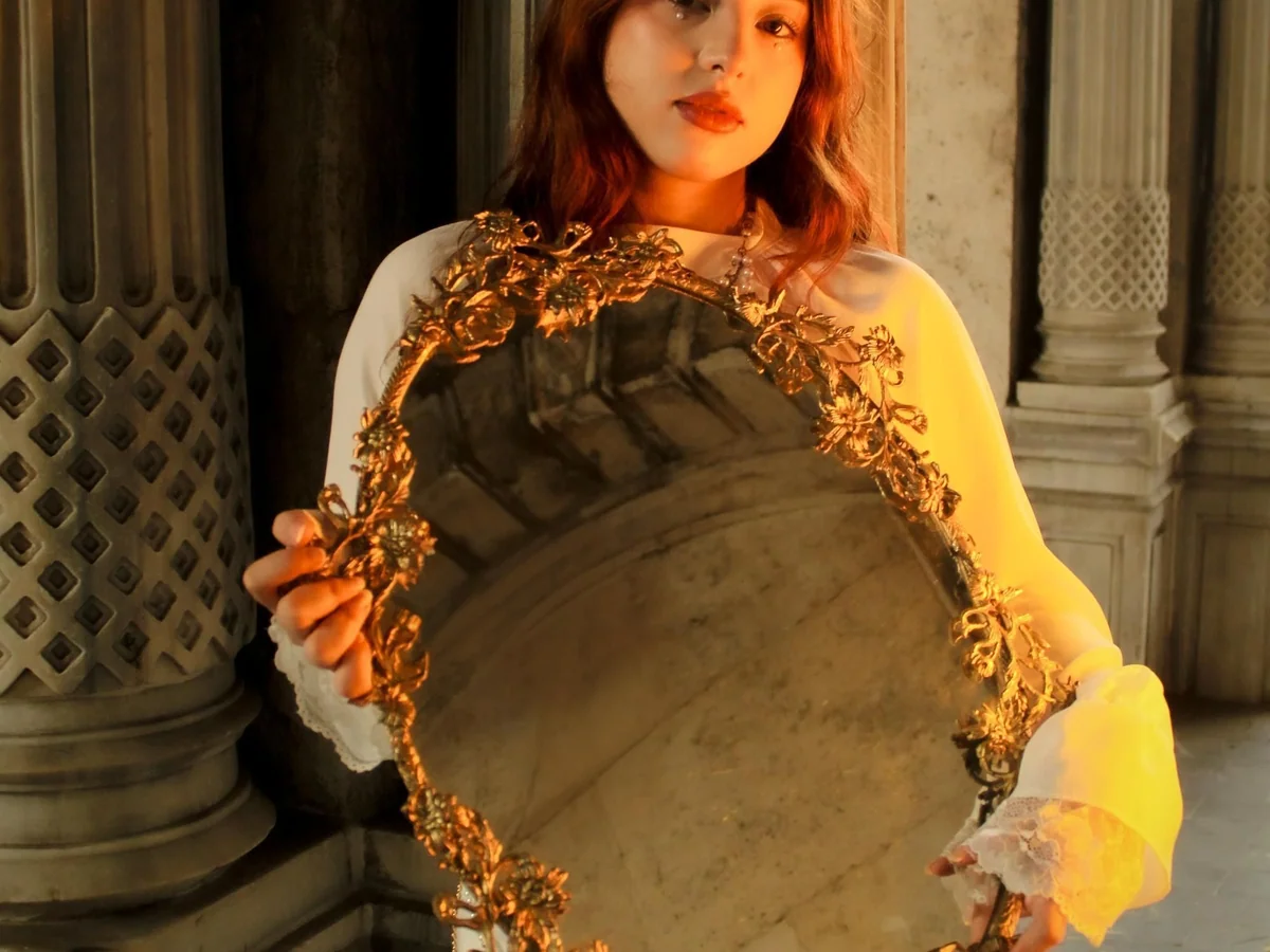 Woman arranging an uncluttered beauty routine at a bathroom mirror